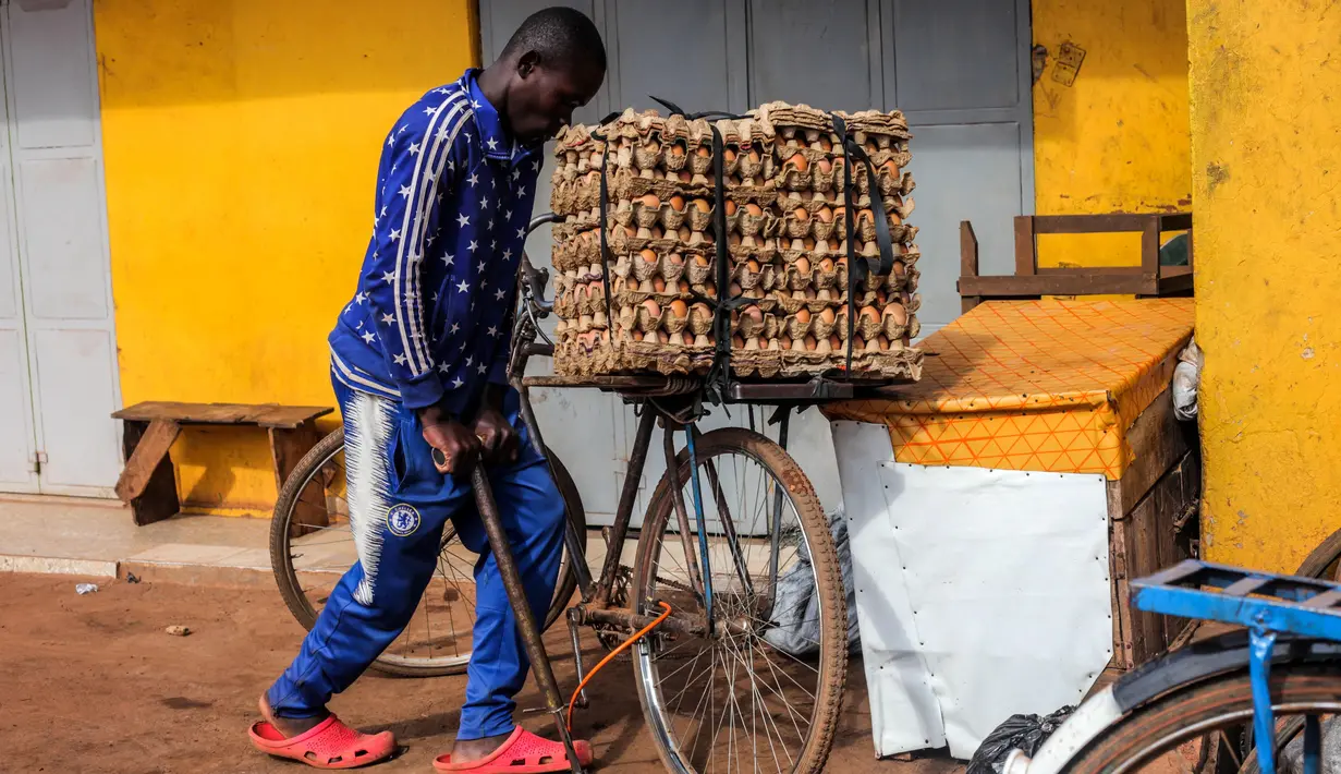 Seorang pria memompa ban sepedanya di Kampala, ibu kota Uganda (30/6/2020). Warga Uganda kini beralih menggunakan sepeda sebagai sarana transportasi yang mendukung di tengah pandemi COVID-19. (Xinhua/Hajarah Nalwadda)