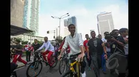 Presiden Joko Widodo mengayuh sepeda melewati jalur car free day (CFD) di kawasan Bundaran HI, Jakarta, Minggu (25/1/2015). (Liputan6.com/Faizal Fanani)