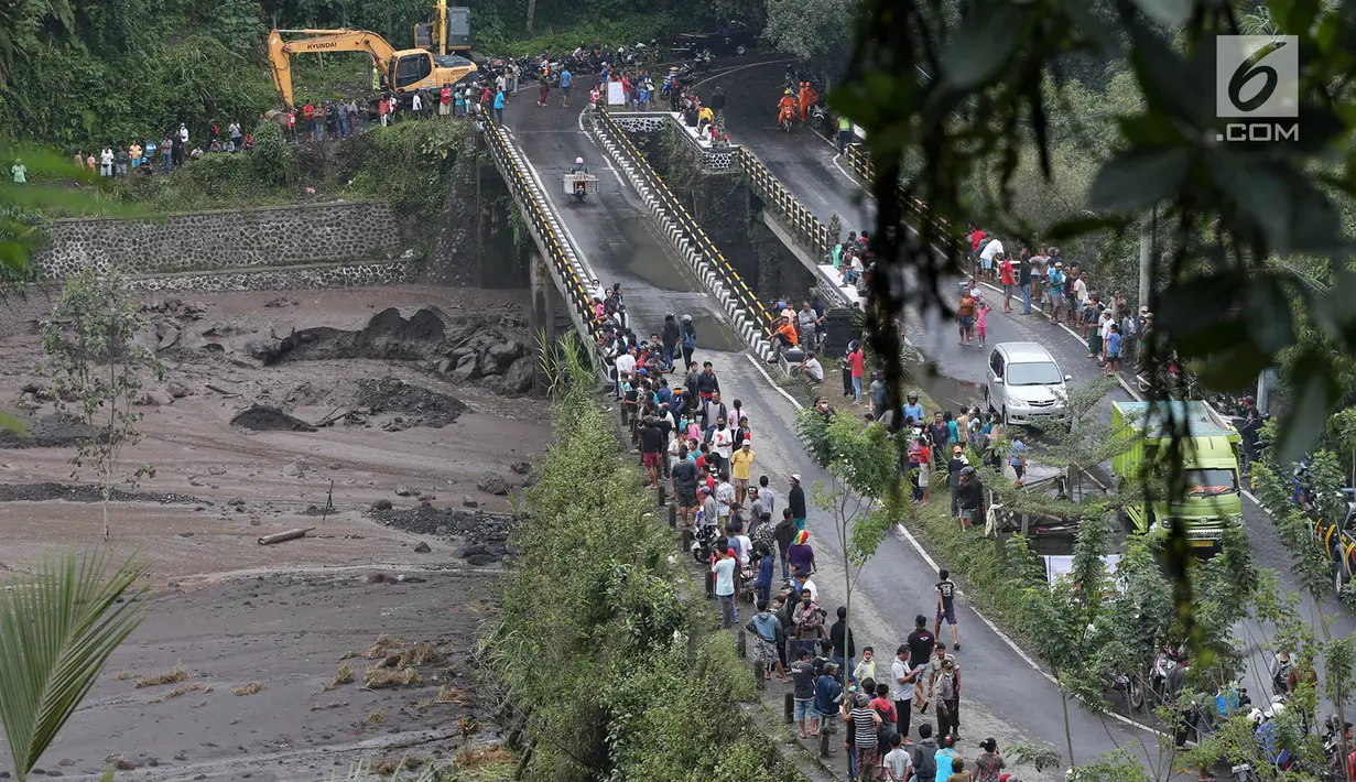 Warga beramai-ramai menyaksikan aliran lahar dingin yang melintasi Sungai Yeh Sah di Karangasem, Bali, Sabtu (2/12). Banjir lahar dingin dari Gunung Agung tersebut mengundang perhatian warga sekitar. (Liputan6.com/Immanuel Antonius)
