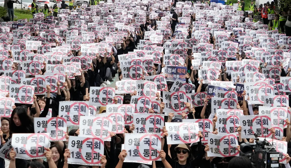 Spanduk yang dibawa para pengunjuk rasa berisi slogan-slogan yang berbunyi "Meloloskan (RUU Pemulihan Hak Guru) pada Sidang Parlemen bulan September."  (AP Photo/Ahn Young-joon)