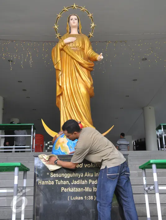 Panitia terlihat membersihkan patung Bunda Maria yang terletak di depan gereja Santa Maria, Jakarta Barat, Kamis (24/12). Sejumlah gereja mulai melakukan persiapan untuk menyambut perayaan misa malam Natal. (Liputan6.com/Faisal R Syam)