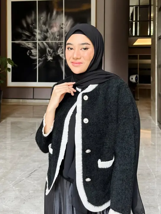 Clara Shinta tampil black on black, ia mengenakan blazer hitam fur dengan list putih. Dipadukan inner dan rok plisket warna senada.  [@clarashintareal]