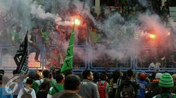 Pendukung Persebaya 1927 atau Bonek menyalakan suar saat aksi di Stadion Tugu, Jakarta, Rabu (3/8). Bonek menyerbu Jakarta sejak Selasa (2/8) untuk mendesak pengakuan klub Persebaya 1927 pada KLB PSSI. (Liputan6.com/Helmi Fithriansyah)