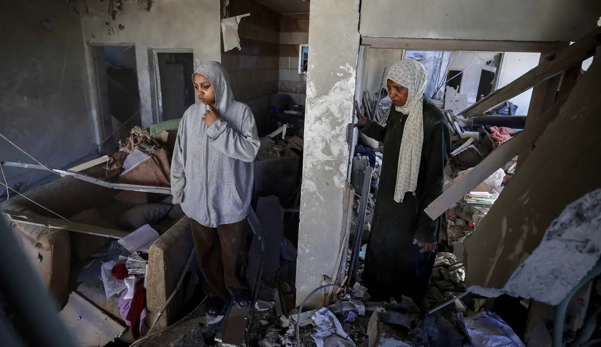 Warga Palestina yang mengungsi memeriksa kerusakan setelah sebuah rumah menjadi sasaran serangan Israel di kamp pengungsi Maghazi, Jalur Gaza Tengah pada Kamis 21 Mei 2026. (Eyad Baba/AFP)