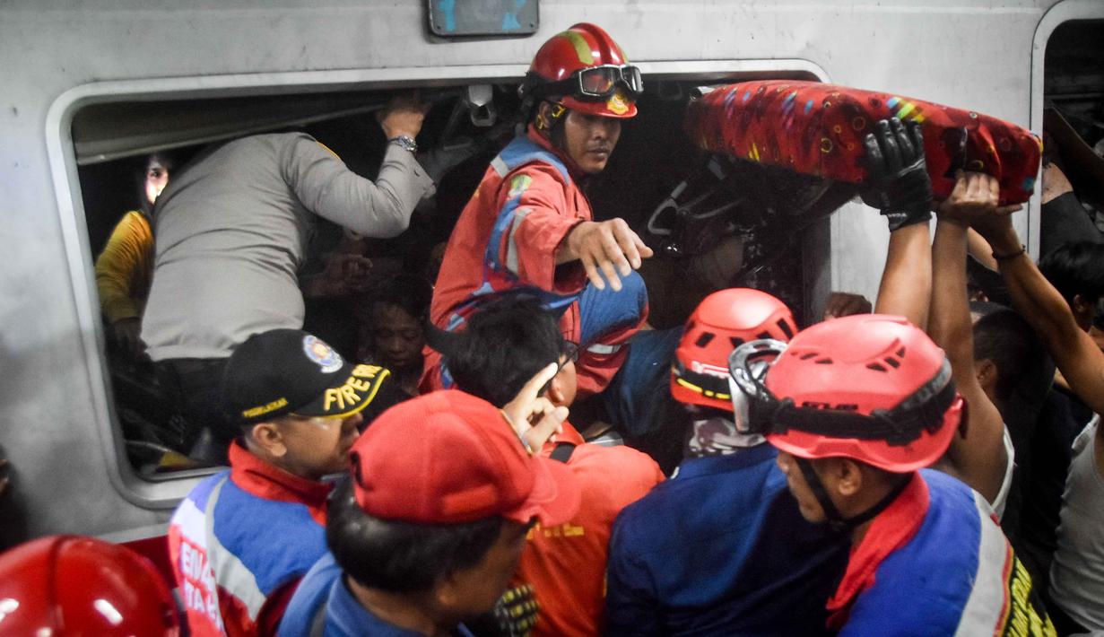Tim pencari dan penyelamat gabungan berupaya menyelamatkan salah satu korban yang terjebak di dalam gerbong setelah lokomotif Kereta Api Jarak Jauh (KAJJ) Argo Bromo Anggrek menabrak gerbong belakang Kereta Rel Listrik (KRL) Commuter Line di stasiun Bekasi Timur, Bekasi, Jawa Barat pada Selasa 28 April 2026. (Rezas/AFP)