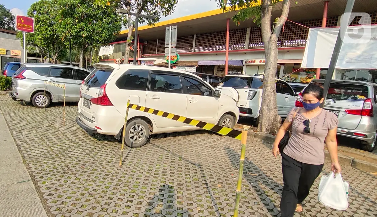 Seorang perempuan melintas di antara mobil yang parkir di Rest Area Km 13,5 di Tol Tangerang, Selasa (19/5/2020). Jelang Lebaran, PT Jasamarga Related Business menerapkan PSBB di semua rest area yang dikelolanya dengan membatasi waktu singgah pengunjung maksimal 30 menit. (Liputan6.com/Angga Yuniar)