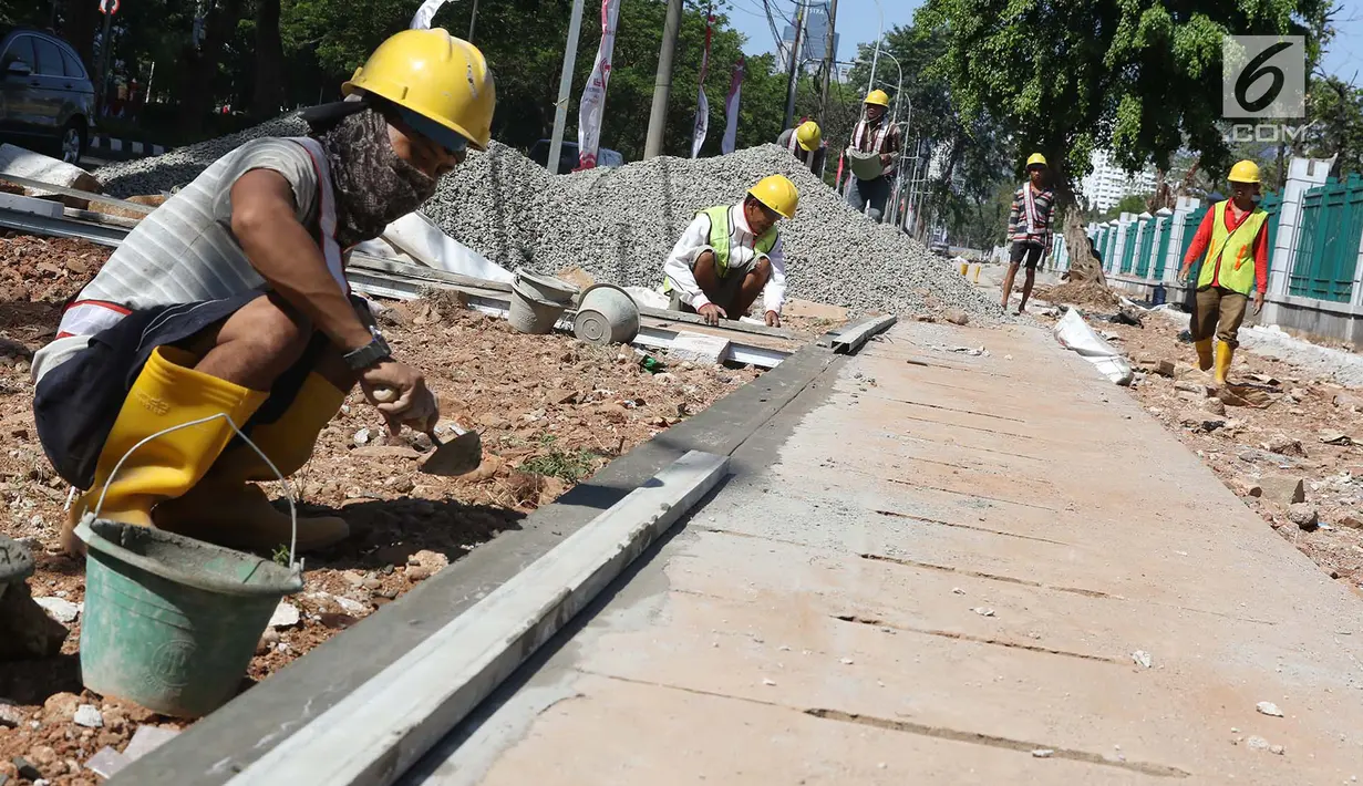 Sejumlah pekerja menyelesaikan pembuatan trotoar di kawasan Senayan, Jakarta, Senin (28/8). Pembuatan trotoar dilakukan dalam rangka menyambut event Asian Games 2018 mendatang yang akan digelar di Jakarta dan Palembang. (Liputan6.com/Immanuel Antonius)