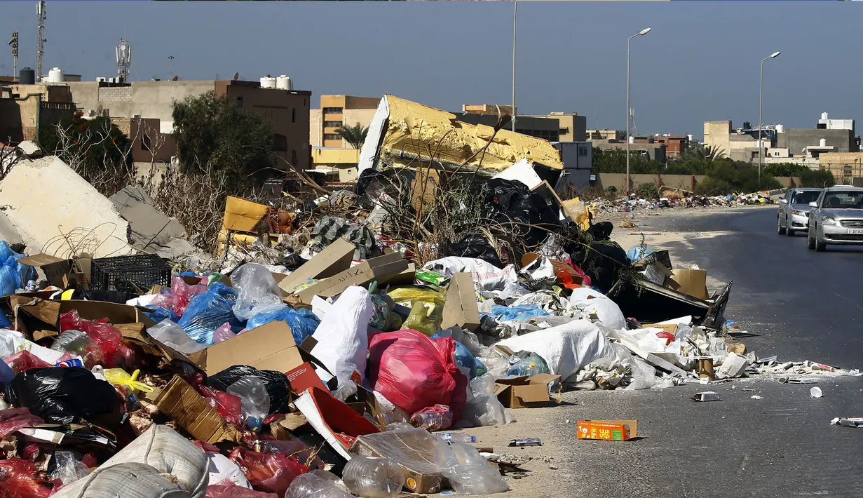 Tumpukan sampah terlihat di sepanjang sisi jalan di Tripoli, ibukota Libya (30/9/2019). Sampah yang berserakan di jalan tersebut menambah cobaan sehari-hari bagi penduduk ibukota yang kehidupannya telah diselingi kekurangan bahan bakar, listrik, dan air. (AFP Photo/Mahmud Turkia)