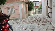 Seorang pria dengan sepeda motor melewati rumah yang rusak setelah gempa bumi di pulau Lesbos, Yunani Timur, Senin (12/6). Sedikitnya 10 orang terluka ketika gempa bumi 6,3 SR mengguncang Laut Aegea di Yunani Timur. (Manolis Lagoutaris/InTime News via AP)