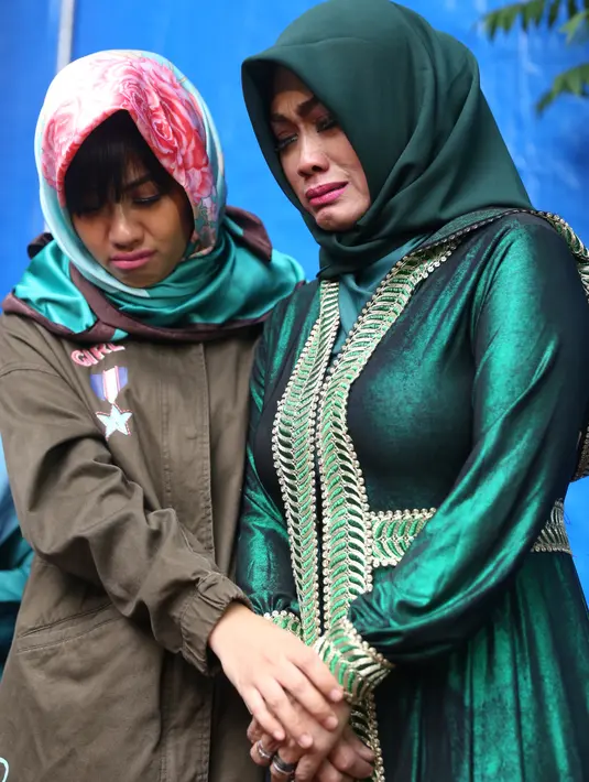 Didampingi kedua anaknya, Nia Anggia dan Della Wulan, Sri Wulansih mendatangi makam Jupe tepat di hari ke-100 anak sulungnya itu meninggal dunia. Di tepi pusara, sang ibu tak kuasa menahan air matanya. (Nurwahyunan/Bintang.com)