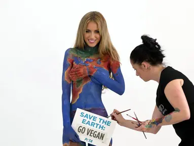 Seniman Jade Little melukis tubuh Renee Somerfield untuk mengkampanyekan Perlakuan Etis terhadap Hewan, Sydney (3/7/2014). (REUTERS/Jason Reed)