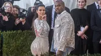 Pasangan Kanye West dan Kim Kardashian mencuri perhatian saat menghadiri ajang Met Gala 2016 di Metropolitan Museum of Art, New York City, Senin (2/5). Keduanya tampil senada mengenakan warna metalik perak. (Mark Sagliocco /Getty Images/AFP)