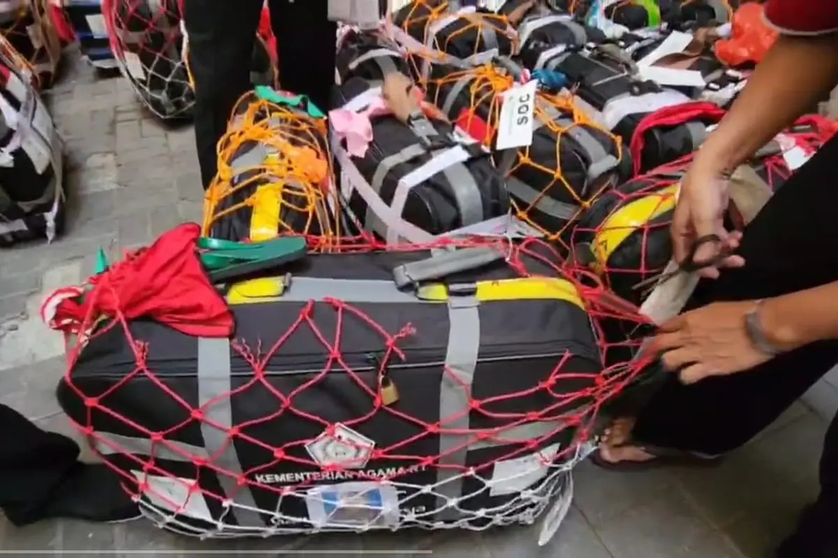 Petugas menggunting jaring koper jemaah haji Indonesia. (Liputan6.com/Mevi Linawati)