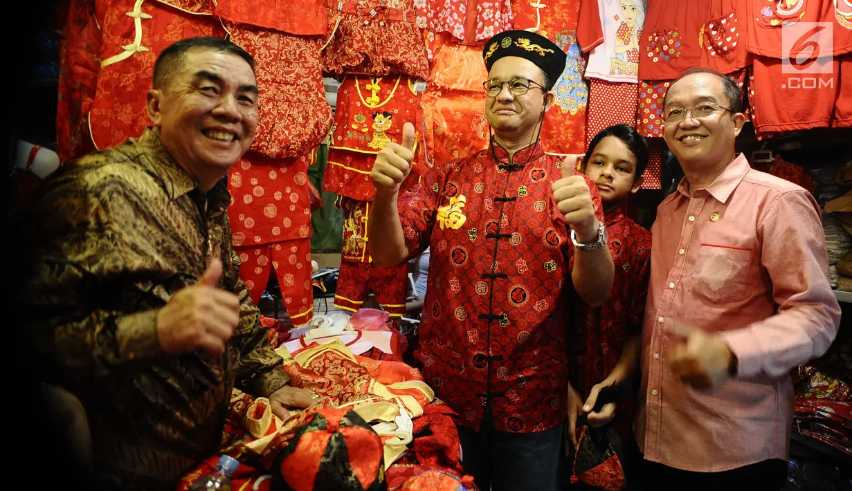 Gubernur DKI, Anies Baswedan berpose mengenakan baju tradisional khas China di toko langganannya di sekitar Vihara Dharma Bakti, Jakarta Barat, Jumat (16/2). Anies mengisi libur Imlek dengan datang ke Vihara Dharma Bakti. (Liputan6.com/Gempur M Surya)