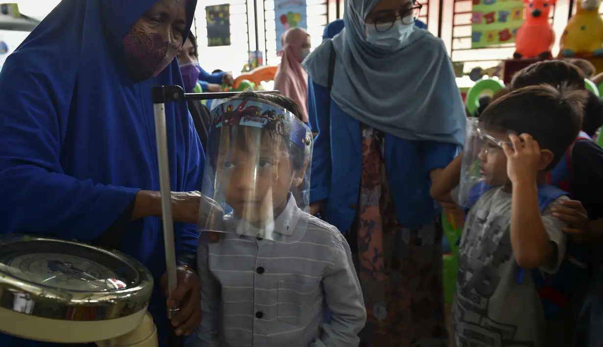 Seorang anak diukur tumbuh kembangnya sebelum menerima vaksin campak dan polio di sebuah posyandu di Banda Aceh, Aceh, Rabu (4/10/2020). Pemberian vaksin polio dan vaksin campak secara gratis yang berlanjut di tengah pandemi COVID-19 bertujuan memperkuat imunitas anak. (CHAIDEER MAHYUDDIN / AFP)