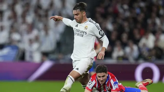 Striker Atletico Madrid Julian Alvarez (kanan) berduel dengan bek Real Madrid Raul Asencio dalam laga leg pertama babak 16 besar Liga Champions, Rabu (5/3/2025). (c) AP Photo/Manu Fernandez