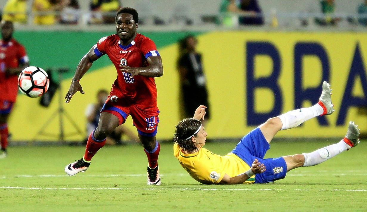 Pemain Haiti, Jeff Louis (kiri) merebut bola dari pemain Brasil, Filipe Luis pada penyisihan grup B Copa America Centenario 2016 di Orlando, Florida, AS, (9/6/2016) WIB. Brasil menang 7-1. (AFP/ Gregg Newton)