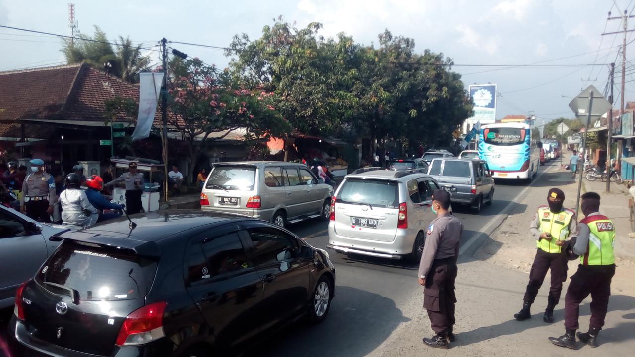 Sejumlah anggota kepolisian tengah mengamankan antrian kendaraan arus balik di dekat pospam Limbangan, Garut