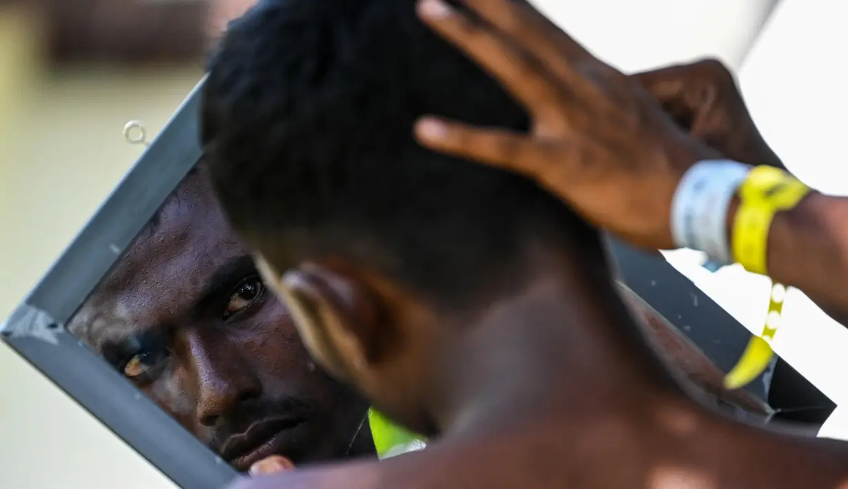 Pengungsi Rohingya beristirahat di tempat penampungan sementara di Ladong, provinsi Aceh, Jumat 24 Februari 2023. Puluhan imigran Rohingya tersebut berlayar dengan kapal kayu berukuran 15x4 meter dan terdampar di pesisir pantai tepatnya di Desa Lampanah Leungah Kecamatan Seulimum, Kabupaten Aceh Besar, Kamis (16/2) lalu. Dari hasil pendataan 69 pengungsi Rohingya tersebut terdiri dari laki-laki dewasa 26 orang, perempuan dewasa 23, dan anak-anak 20 orang. (CHAIDEER MAHYUDDIN/AFP)