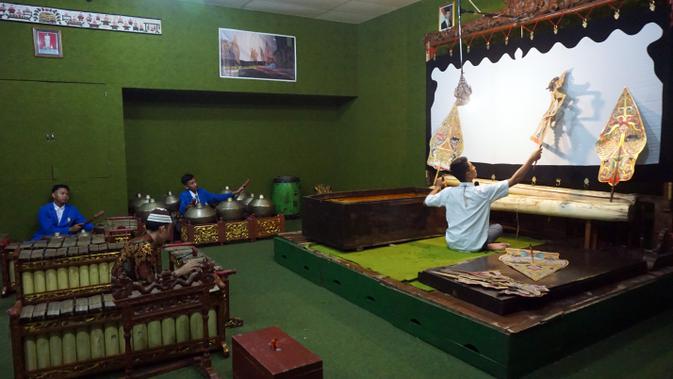 Rasino dan siswanya sedang memainkan gamelan untuk mengiri ujian perdalangan di SMKN 8 Surakarta.(Liputan6.com/Fajar Abrori)