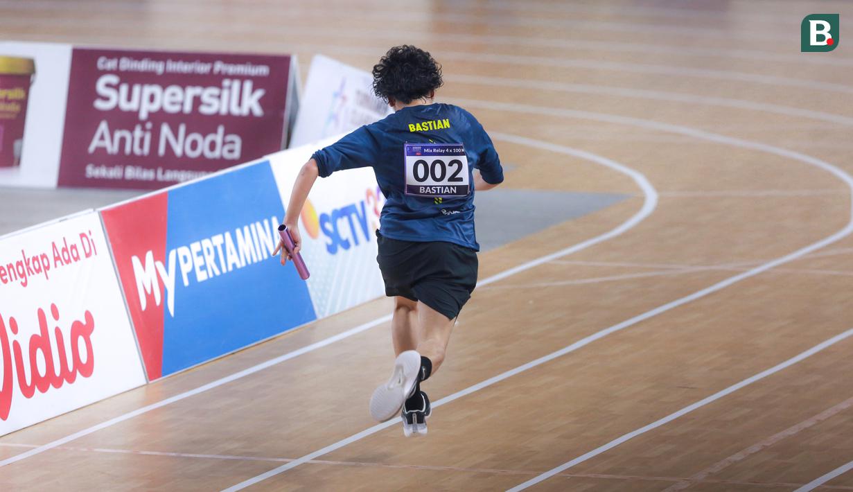 Selebritas Indonesia, Bastian Steel berlomba pada cabang olahraga lari estafet 400 meter nomor campuran Turnamen Olahraga Selebriti Indonesia (TOSI) di GOR UNJ, Rawamangun, Jakarta, Minggu (30/07/2023). Timnya berhasil finis dengan catatan waktu 1 menit 0,59 detik. (Bola.com/Bagaskara Lazuardi)