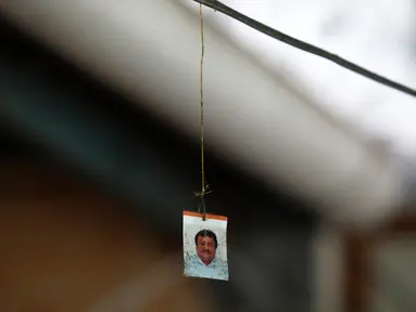 Potret wartawan Leobardo Vazquez yang tergantung di kabel tempat ia ditemukan tewas di depan rumahnya di Gutierrez Zamora, Meksiko (22/3). Vazquez ditemukan tewas terbunuh di dekat kios taco miliknya. (AP/Felix Marquez)