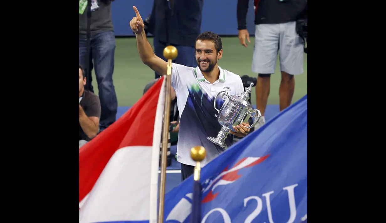 Petenis Kroasia, Marin Cilic, tersenyum sambil memeluk trofi saat menjuarai turnamen tenis US Open 2014, New York, (8/9/2014). (REUTERS/Adam Hunger) 