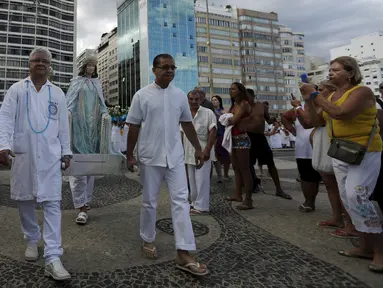 Sejumlah pengikut agama Afro - Brazilian Umbanda membawa persembahan untuk Iemanja, di Pantai Copacabana di Rio de Janeiro, Brasil, (29/12). Iemanja merupakan dewi laut yang dipuja oleh agama tersebut. (REUTERS/Ricardo Moraes)