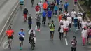 Peserta ToleRun 2016 berbaur dengan pengguna jalan lainnya saat lari di kawasan Jalan Jend Sudirman, Jakarta, Minggu (20/11). Diikuti ratusan peserta, ToleRun 2016 mengambil tema Bergerak untuk Bhinneka Tunggal Ika. (Liputan6.com/Helmi Fithriansyah)