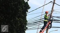 Pekerja mengecek instalasi kabel di tiang listrik milik PLN, Jakarta, Jumat (26/2). PLN menjaga mutu keandalan penyaluran tenaga listrik, memenuhi ketentuan keselamatan ketenagalistrikan, dan estetika tata kota Jakarta. (Liputan6.com/Immanuel Antonius)