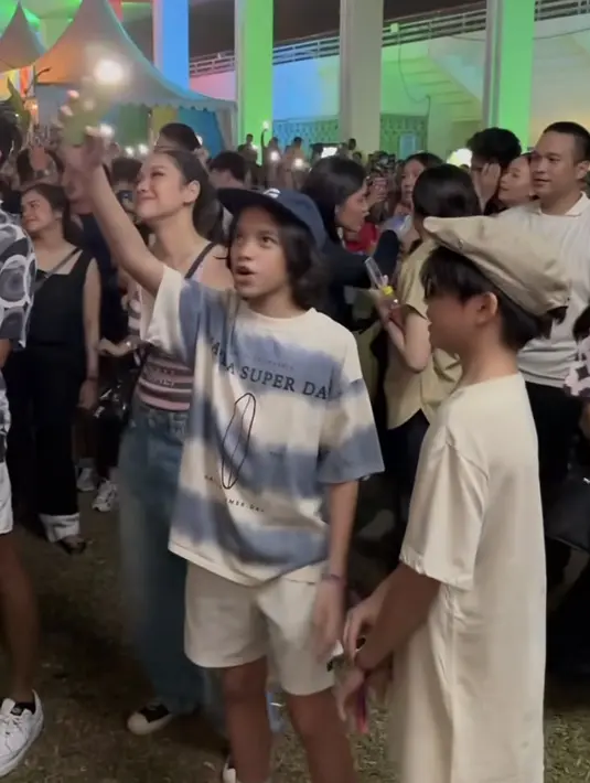 Bunga Citra Lestari juga hadir menemani anak semata wayangnya. Perempuan yang akrab disapa BCL ini tampil dengan spaghetti strap Dior bergaris pink abu-abu dipadukan celana denim oversize. @bclinclair