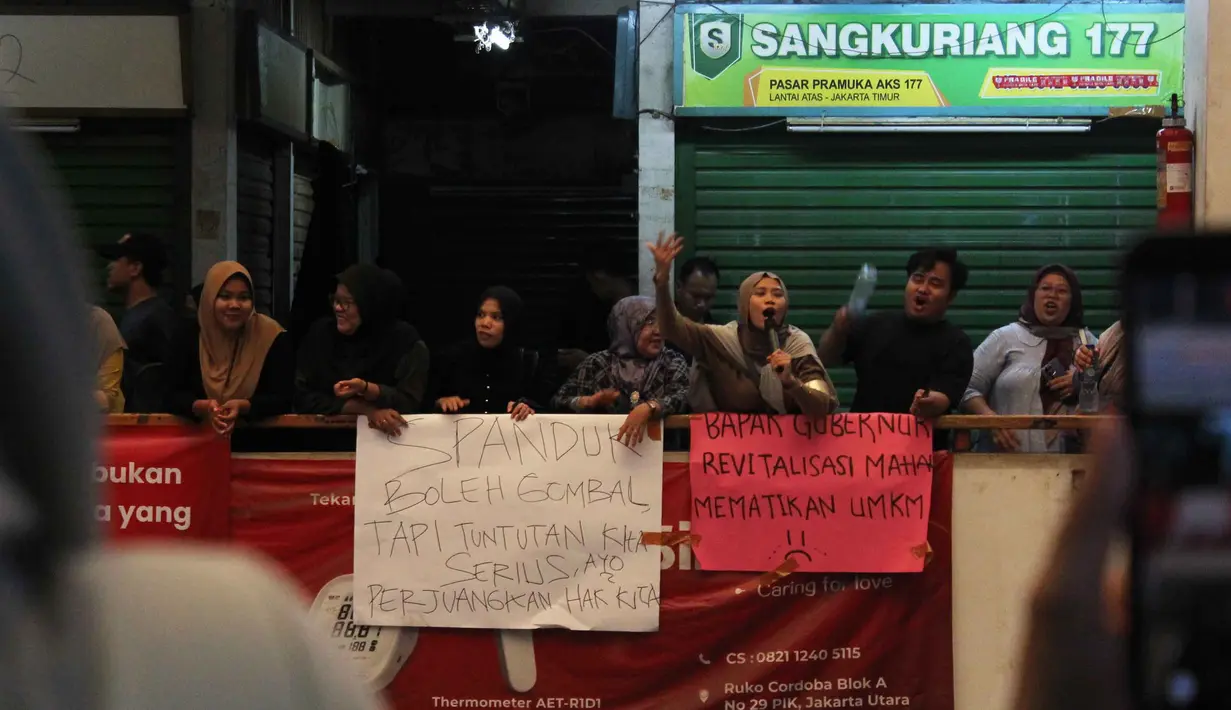 Para pedagang keberatan dengan kenaikan harga sewa kios yang dinilai terlalu tinggi, bahkan mencapai empat kali lipat setelah revitalisasi. Tampak dalam foto, para pedagang melakukan aksi protes di dalam Pasar Pramuka, Jakarta Timur, Jumat (14/11/2025). (merdeka.com/magang/Rendi Saputra)