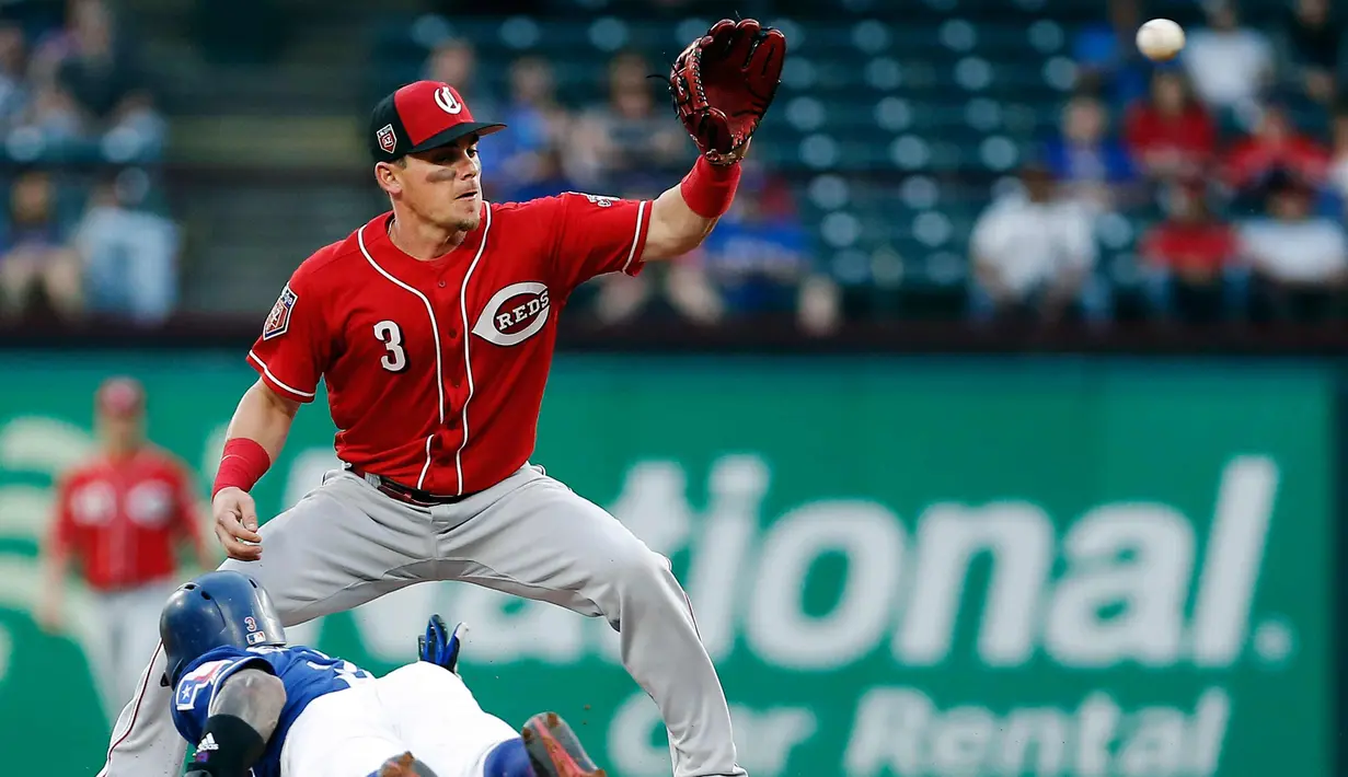 Pemain Cincinnati Reds, Patrick Kivlehan (atas) menangkap bola pukulan pemain Texas Rangers, Tyler Mahle selama inning pertama dari pertandingan bisbol pramusim di Arlington, Texas (26/3). (AP Photo/Brandon Wade)