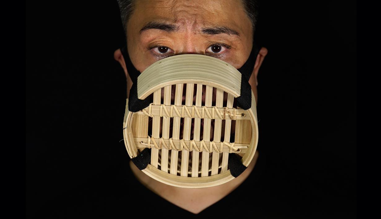 Edmond Kok, aktor dan desainer kostum teater Hong Kong, mengenakan masker wajah yang terbuat dari kukusan bambu China di Hong Kong pada 6 Agustus 2020. Sepanjang pandemi, Edmond telah membuat lebih dari 170 masker yang terinspirasi oleh pandemi dan masalah politik Hong Kong. (AP Photo/Vincent Yu)
