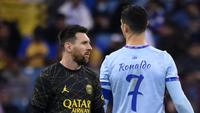Penyarang Paris Saint-Germain, Lionel Messi (kiri) berjalan melewati pemain Riyadh All-Star, Cristiano Ronaldo, saat laga persahabatan Stadion King Fahd, di Riyadh, Arab Saudi, Jumat (20/1/2023) dini hari WIB. (AFP/Frank Fife)