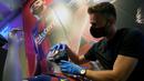 Penjaga toko memasang masker berlogo Barcelona ke Manekin di Toko Asesoris Barcelona, Senin (25/5/2020). Di tengah pandemi virus Corona, Barcelona menjual masker dengan harga 18 euro atau sekitar Rp 291 ribu. (AFP/Lluis Gene)