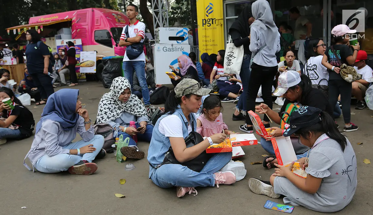 Pengunjung menikmati makan sambil lesehan jelang Closing Ceremony Asian Games 2018 di kawasan Gelora Bung Karno, Jakarta, Minggu (2/9). Mereka mengisi perut sebelum Closing Ceremony. (Liputan6.com/Fery Pradolo)