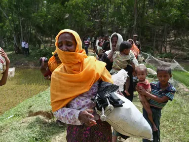 Sejumlah warga Rohingya saat dihadang petugas perbatasan di Ghumdhum, Bangladesh, (28/8). Ribuan muslim Rohingya di Rakhine, Myanmar, melarikan diri dan terjebak di perbatasan Myanmar - Bangladesh. (AP Photo/Mushfiqul Alam)