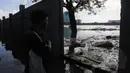 Hujan yang mengguyur Jakarta sejak Minggu (8/2) lalu, membuat Waduk Ria Rio meluap. Tampak seorang warga melihat danau yang meluap, Jakarta, Selasa (10/2/2015). (Liputan6.com/Herman Zakharia)