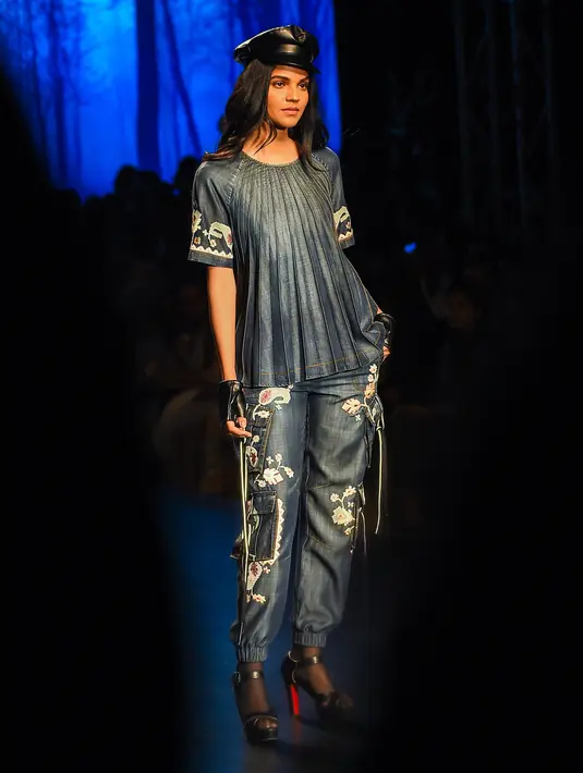 Model berpose di atas catwalk membawakan busana Autumn Winter 2018 karya desainer asal India, Vineet Bahl selama Amazon India Fashion Week di New Delhi (15/3). (AFP Photo/Chandan Khanna)