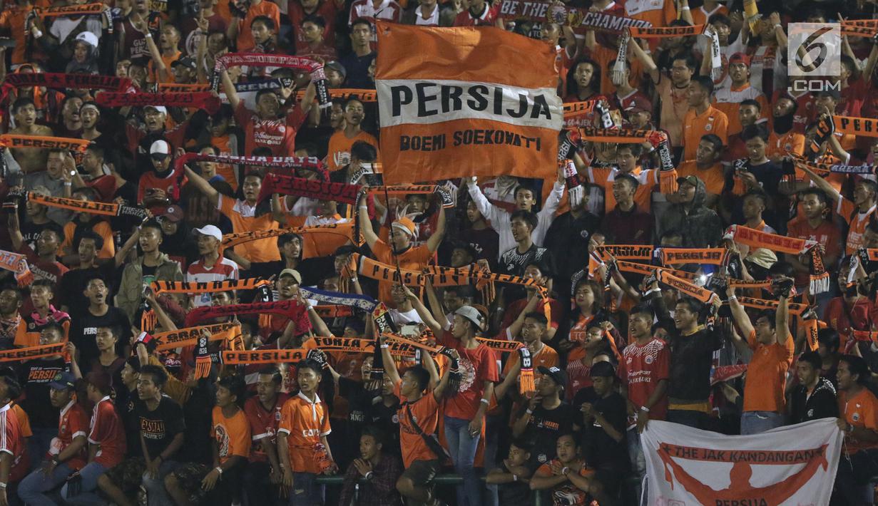 Suporter tim Macan Kemayoran mengibarkan bendera saat menyaksikan laga Persija melawan PSMS di laga pertama semifinal Piala Presiden 2018 di Stadion Manahan, Solo, Jawa Tengah, Sabtu (10/2). Persija menang 4-1. (Liputan6.com/Helmi Fithriansyah)