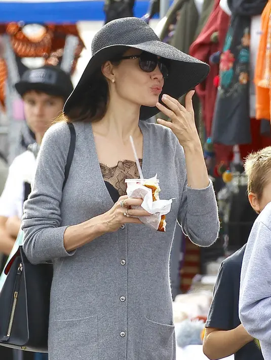 Dirinya menggunakan cardigan abu-abu yang dilengkapi dengan floppy berwarna hitam. (Backgrid/Lainey Gossip)