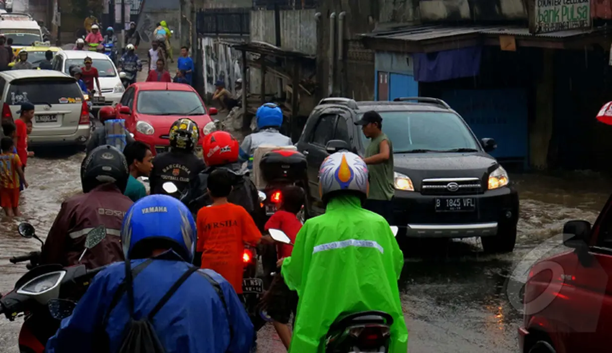 Sejumlah kendaraan mengantri untuk melintasi genangan air setinggi 20cm, di Jalan Joglo Raya, Kampung Gebyuran, Ciledug, Tangerang, Jum'at (23/01/2015). (Liputan6.com/Andrian M Tunay)