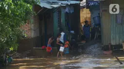 Warga membersihkan rumah dari sisa lumpur  di Bukit Duri, Jakarta, Jumat (29/10/2021). Hujan dengan intensitas tinggi beberapa hari lalu membuat aliran sungai ciliwung meluap yang merendam sebagian rumah warga yang tinggal di bantaransungai  tersebut. (merdeka.com/Imam Buhori)
