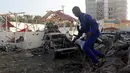 Tentara berjaga di sekitar bangunan yang hancur menyusul serangan bom mobil kembar di Ibu Kota Mogadishu, Somalia, Sabtu (24/2). Ledakan kedua terjadi di dekat Istana Presiden Somalia. (AP Photo/Farah Abdi Warsameh)