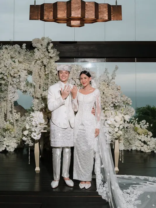 Angga tampil gagah kenakan beskap putih berpayet dengan celana putih. Dipadu dengan kain tenun silver dan penutup kepala [@angga]