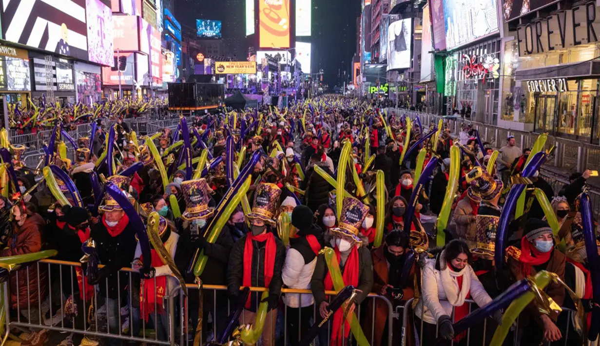Orang-orang berkumpul saat perayaan malam Tahun Baru di Times Square, New York City, Amerika Serikat, Jumat (31/12/2021). (Yuki IWAMURA/AFP)