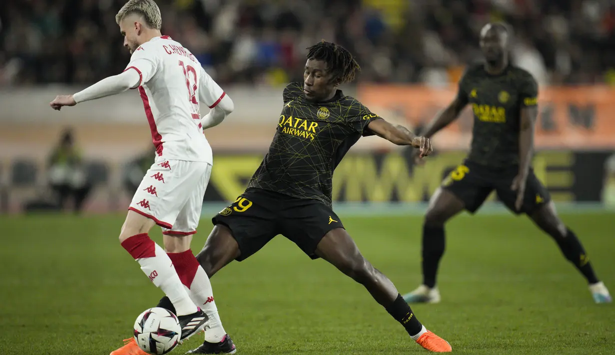 Bek AS Monaco Caio Henrique berebut bola dengan bek Paris Saint-Germain (PSG) Timothee Pembele dalam laga Ligue 1 2022/2023 pekan ke-23 di Stade Louis II, Sabtu (11/2/2023) malam WIB. Satu-satunya gol Les Parisiens pada pertandingan ini dilesakkan oleh pemain 16 tahun Warren Zaire-Emery (39'). (AP Photo/Daniel Cole)