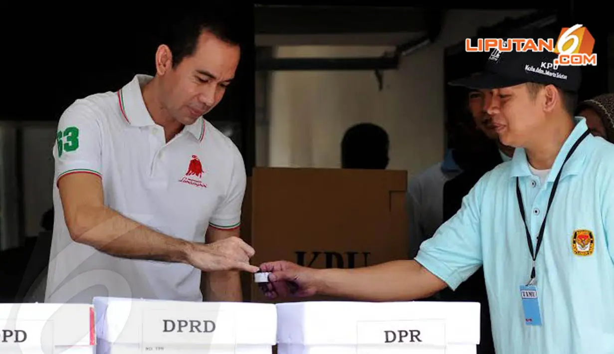 engan wajah kalem, Tubagus Chaeri Wardana menggunakan hak pilihnya dan   mencelupkan ujung kelingkingnya ke tinta ungu (Liputan6.com/Johan Tallo)