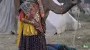 Seorang wanita bereaksi terhadap kamera saat pameran ternak tahunan di Pushkar, India, 11 November 2021. Pushkar adalah tempat ziarah Hindu populer yang juga sering dikunjungi oleh turis asing pada pameran ternak tahunannya. (AP Photo/Deepak Sharma)